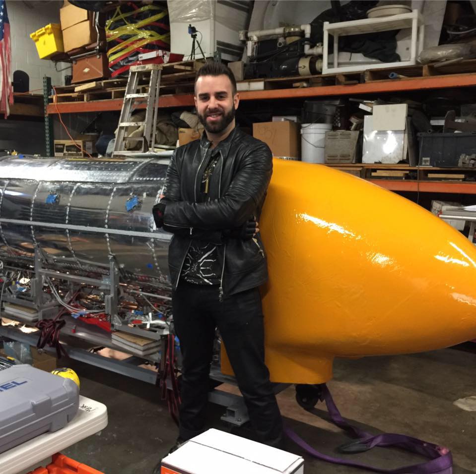 Eric Matzner standing in front of an orange Hyperloop pod